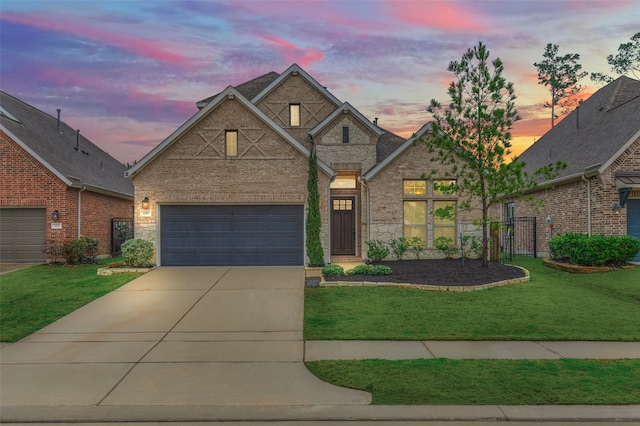 traditional-style home with brick siding, a lawn, fence, stone siding, and driveway