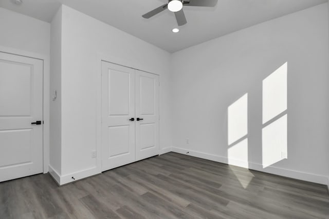 unfurnished bedroom featuring hardwood / wood-style floors, ceiling fan, and a closet