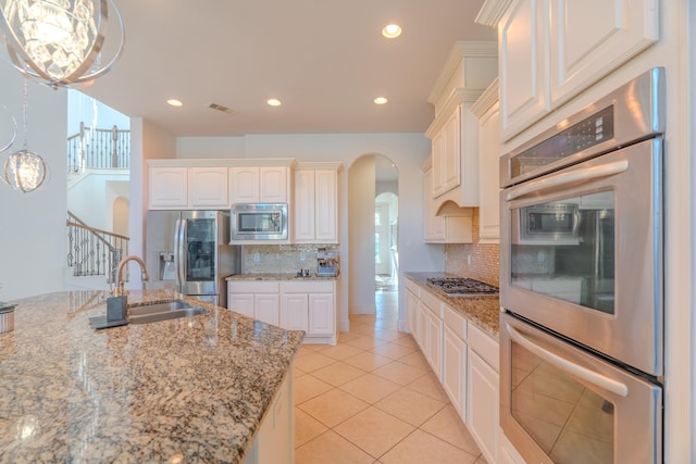 kitchen with white cabinetry, stainless steel appliances, and backsplash