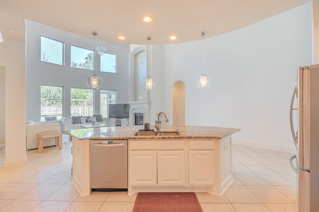 kitchen with pendant lighting, stainless steel appliances, sink, and light tile patterned floors