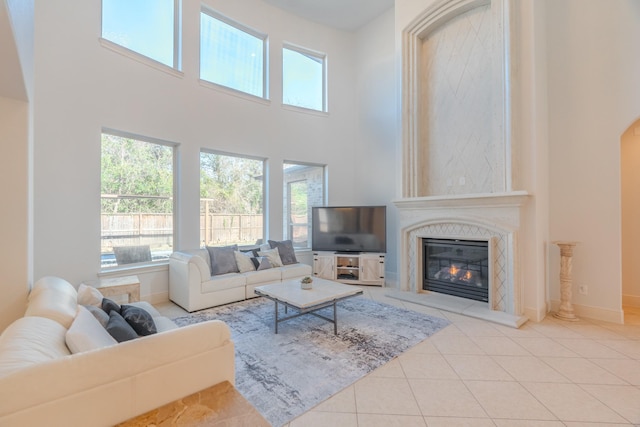 tiled living room with a towering ceiling and a fireplace