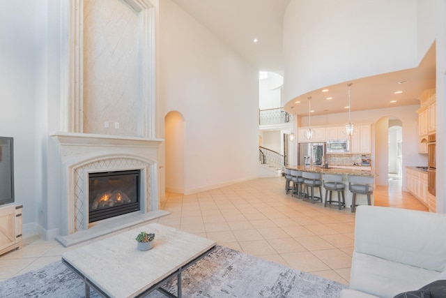 tiled living room featuring a towering ceiling