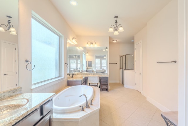 bathroom featuring vanity, a healthy amount of sunlight, tile patterned floors, and an inviting chandelier