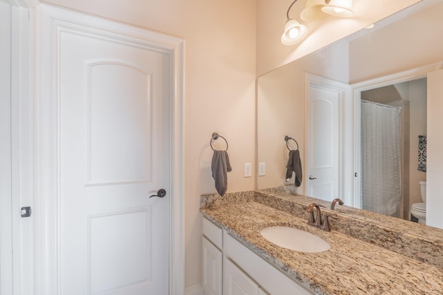 bathroom featuring vanity, toilet, and a shower with shower curtain