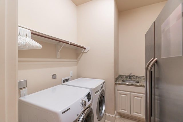 washroom featuring washer and dryer, sink, light tile patterned floors, and cabinets