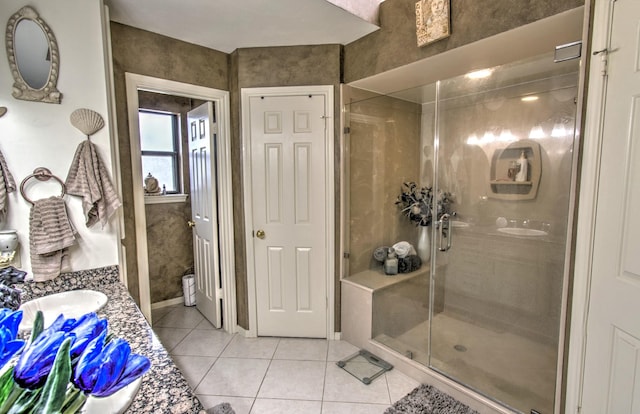 bathroom with tile patterned flooring, vanity, and walk in shower