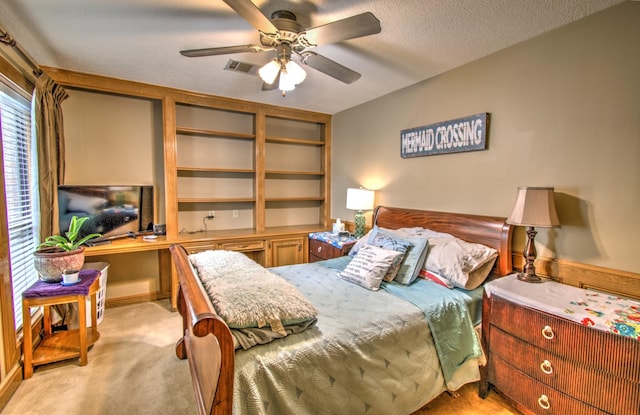 carpeted bedroom with ceiling fan and a textured ceiling