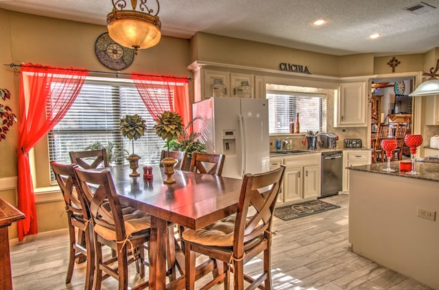 dining area with sink and a textured ceiling