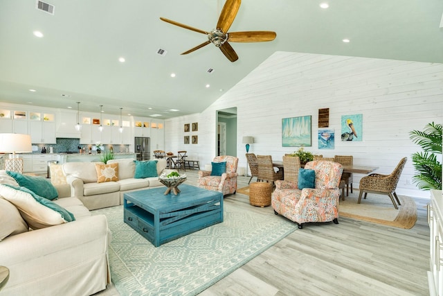 living room featuring high vaulted ceiling, ceiling fan, and light wood-type flooring