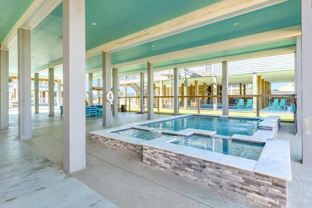 view of swimming pool with an indoor in ground hot tub and a patio area