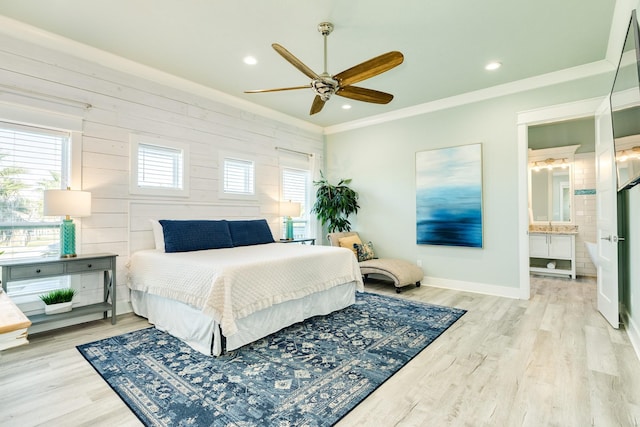 bedroom featuring ceiling fan, ensuite bathroom, light hardwood / wood-style floors, and ornamental molding