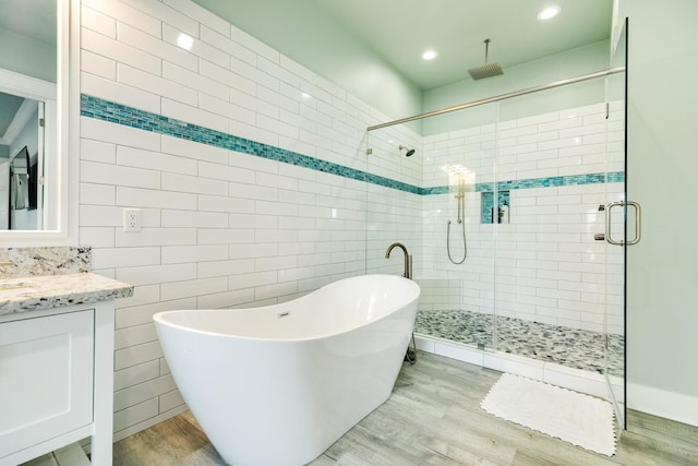 bathroom with vanity, hardwood / wood-style flooring, and shower with separate bathtub