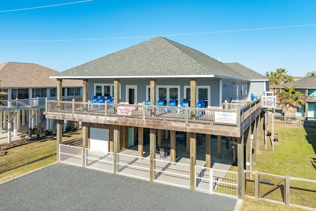 view of front facade featuring a wooden deck, a garage, and a front yard