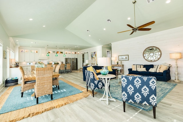 dining room featuring high vaulted ceiling, ceiling fan, and light wood-type flooring