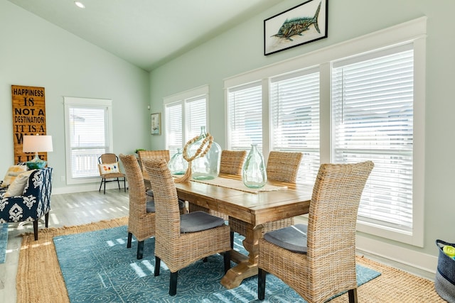 dining space featuring lofted ceiling, light hardwood / wood-style flooring, and a wealth of natural light