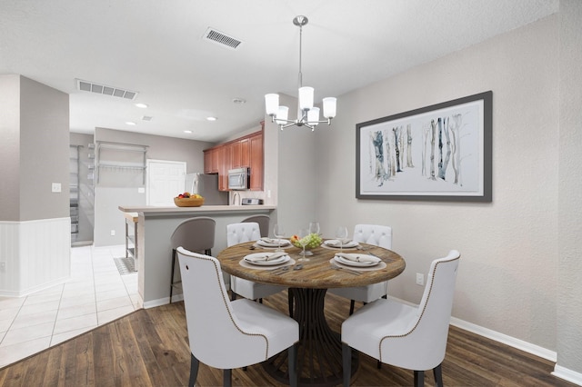 dining space featuring dark hardwood / wood-style floors and an inviting chandelier