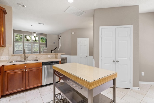 kitchen featuring tasteful backsplash, dishwasher, sink, and light tile patterned flooring