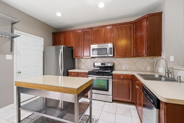 kitchen with tasteful backsplash, appliances with stainless steel finishes, sink, and light tile patterned floors