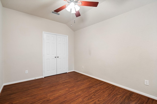 unfurnished bedroom featuring dark hardwood / wood-style flooring, lofted ceiling, a closet, and ceiling fan