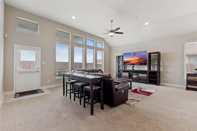 living room with vaulted ceiling, light colored carpet, and ceiling fan