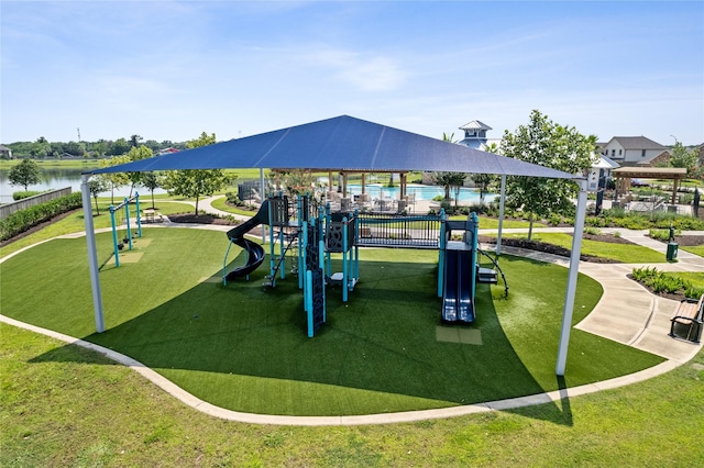 view of jungle gym with a water view and a lawn