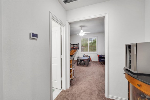 corridor featuring light colored carpet