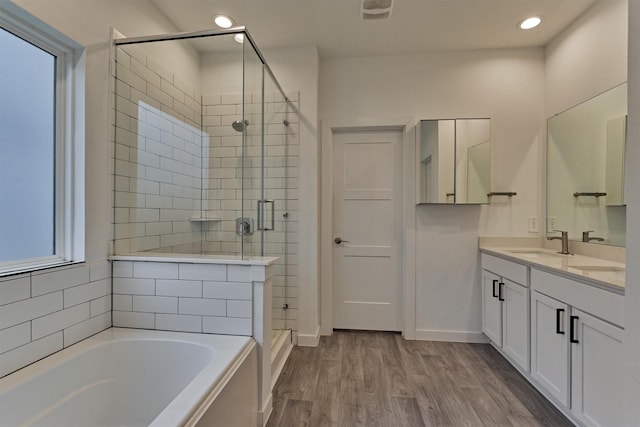 bathroom with hardwood / wood-style flooring, shower with separate bathtub, and vanity