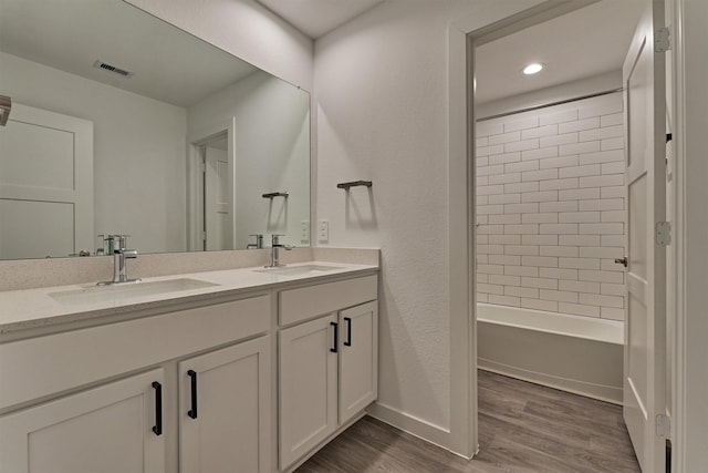 bathroom featuring tiled shower / bath combo, wood-type flooring, and vanity