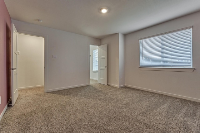 unfurnished bedroom with multiple windows and light colored carpet