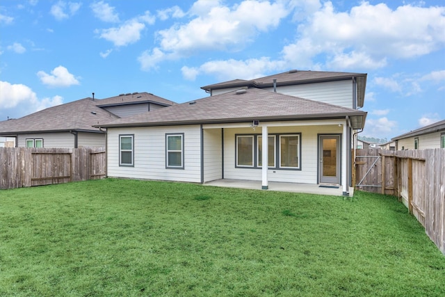 back of house featuring a patio area and a lawn