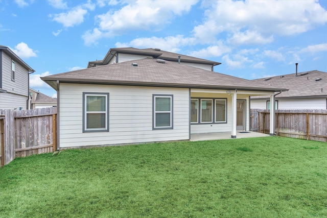 rear view of property with a yard and a patio area