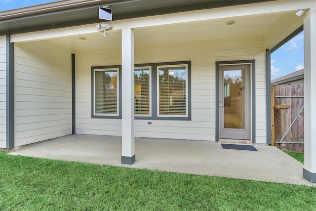 entrance to property with a patio area and a lawn