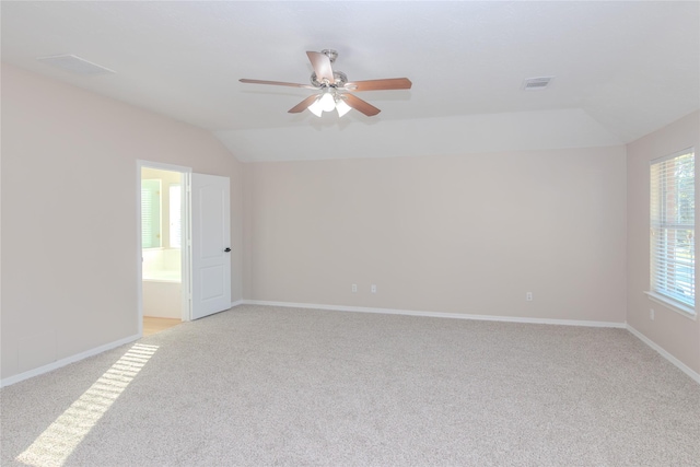 carpeted empty room with vaulted ceiling and ceiling fan