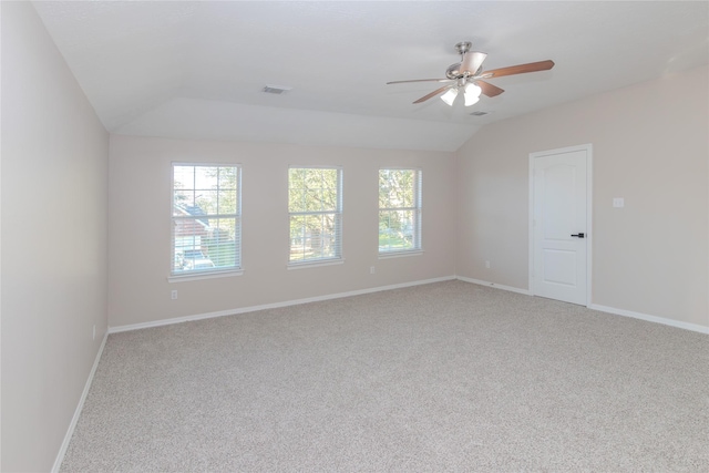 carpeted spare room featuring vaulted ceiling and ceiling fan