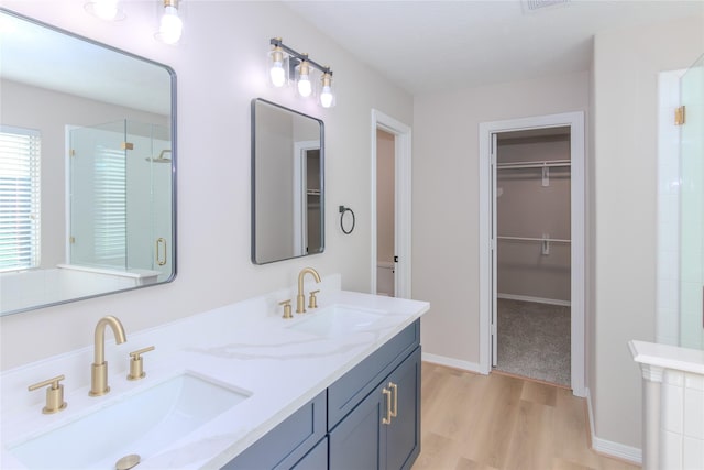 bathroom featuring walk in shower, wood-type flooring, and vanity