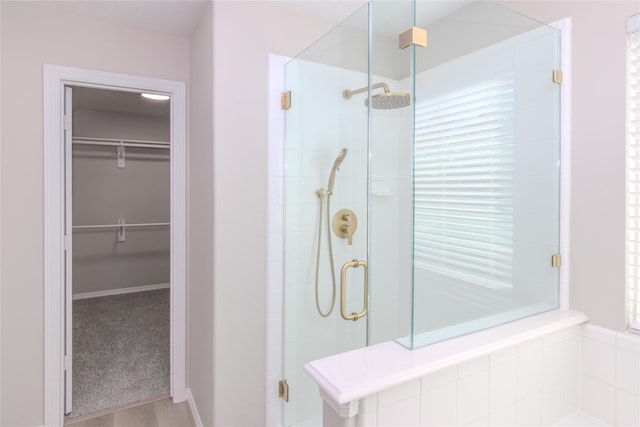 bathroom with wood-type flooring and an enclosed shower