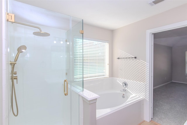 bathroom featuring shower with separate bathtub