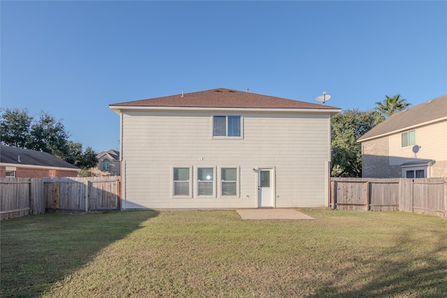 back of house with a yard and a patio