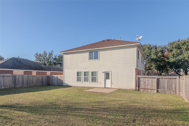 rear view of property with a yard and a patio area