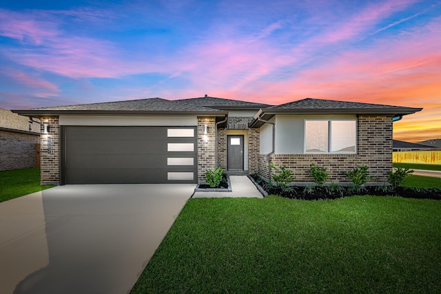 prairie-style home featuring a yard and a garage