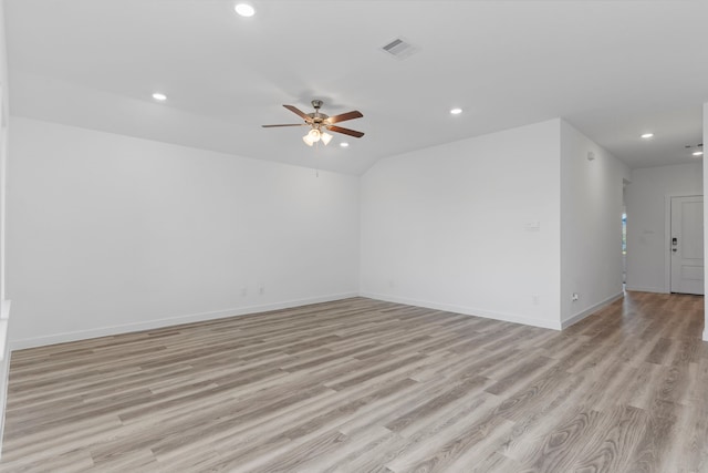 empty room with ceiling fan, vaulted ceiling, and light hardwood / wood-style flooring