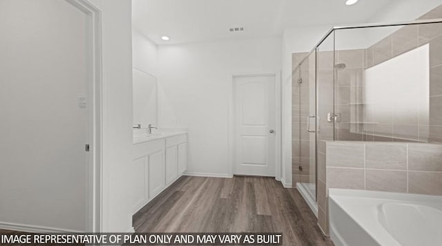 bathroom featuring plus walk in shower, hardwood / wood-style floors, and vanity