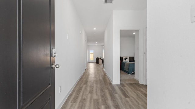 hallway with light hardwood / wood-style floors