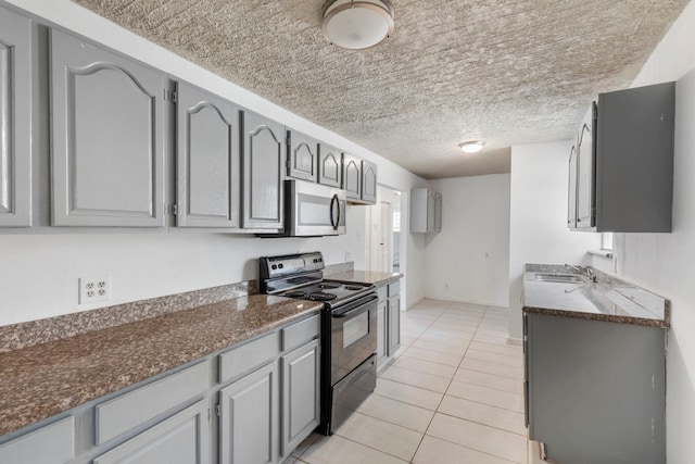 kitchen with gray cabinets, light tile patterned flooring, sink, black electric range, and a textured ceiling