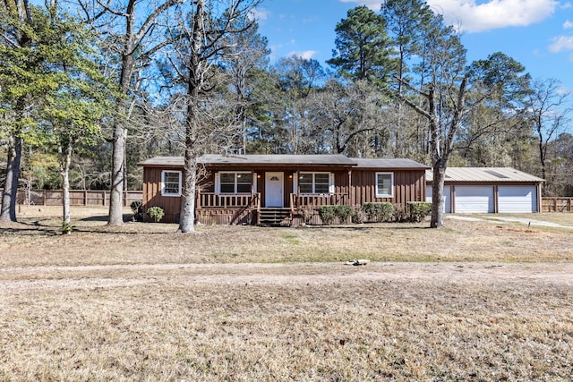 ranch-style house featuring a garage, covered porch, and a front yard