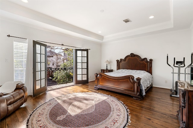 bedroom featuring a raised ceiling, dark wood-type flooring, access to outside, and french doors