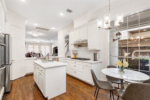 kitchen with a kitchen island, pendant lighting, white cabinetry, kitchen peninsula, and stainless steel appliances