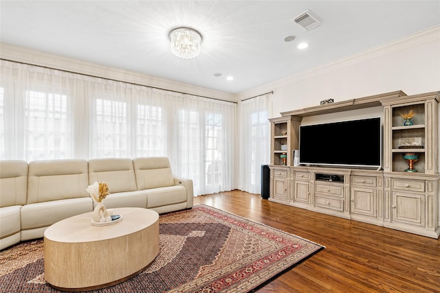 living room with crown molding, hardwood / wood-style floors, and a chandelier