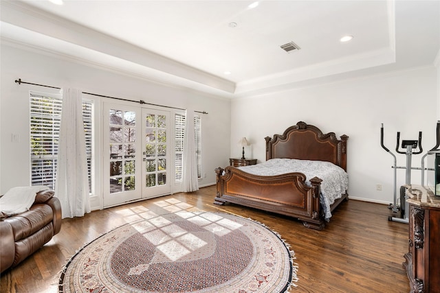 bedroom featuring dark hardwood / wood-style flooring, access to exterior, a tray ceiling, crown molding, and french doors