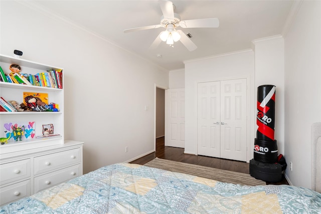 bedroom with crown molding, dark wood-type flooring, ceiling fan, and a closet